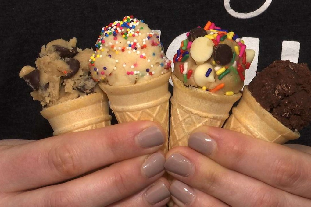 A customer at DO, Cookie Dough Confections, holds four different types of cookie dough in cones. Photo: AP