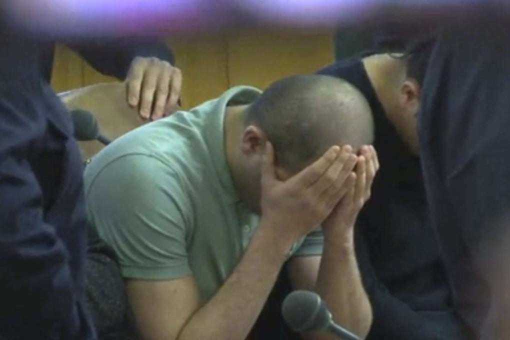 A defendant covers his face at the beginning of his trial on gang-raping a German tourist in Vienna, Austria. Photo: AP