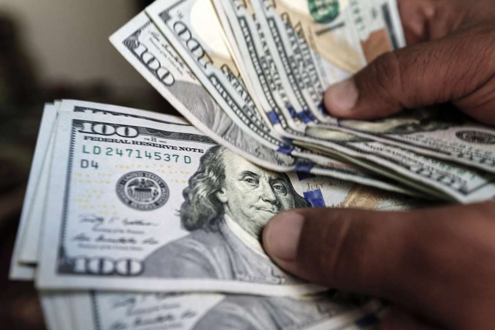 One hundred US dollar notes at a currency exchange office as the greenback hits a 7-week high on expectations of an interest rate increase by the US this month. Photo: AFP