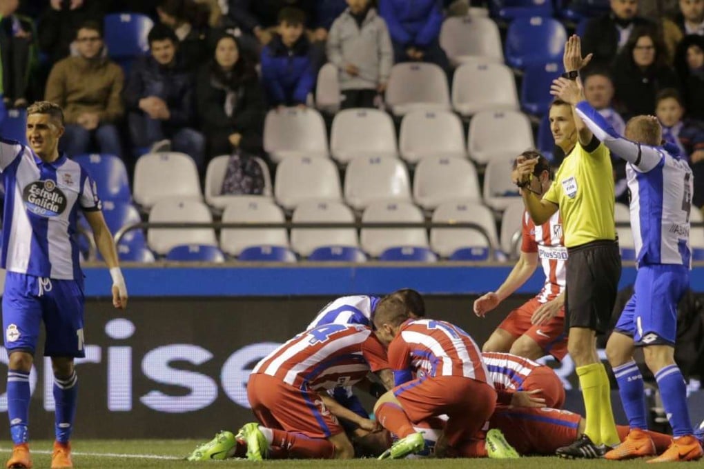 Referee Carlos Clos Gomez calls for medical assistance as Atletico Madrid's Fernando Torres lies injured on the ground. Photo: Reuters