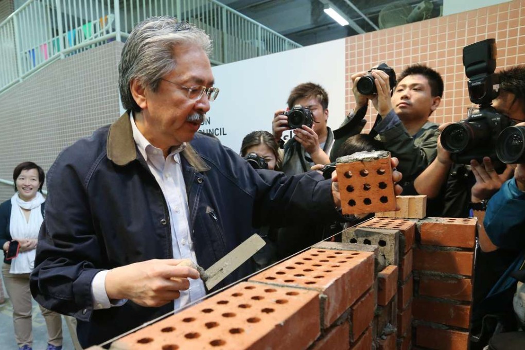 Chief Executive candidate John Tsang tries his hand at brick laying during a training open day in Sheung Shui. Photo: Dickson Lee