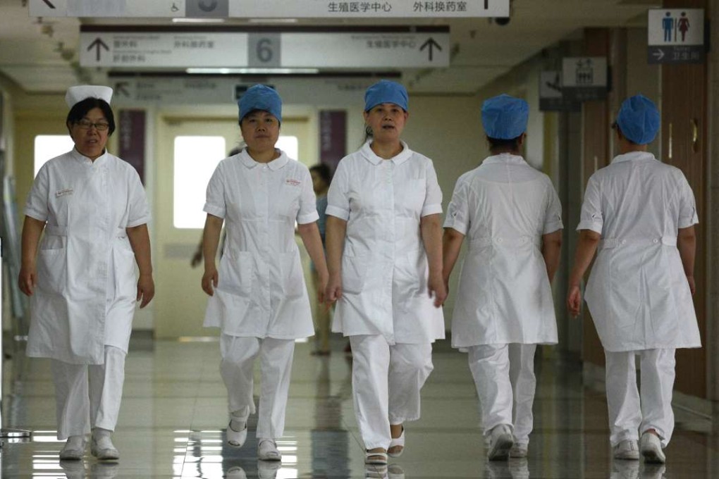 A group of nurses walks along a corridor at a hospital in Beijing. Even the Chinese government admits the current public health care system is under severe pressure. Photo: AFP
