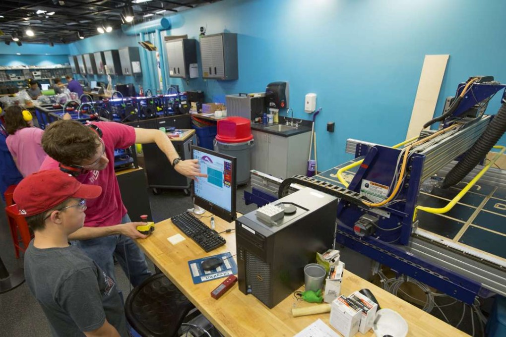 Assisted by a teacher, a student uses a 'ShopBot' for computer-aided design and fabrication during a summer school course at the Museum of Science and Industry's Wanger Family Fab Lab in Chicago in 2015. Photo: J.B. Spector/Museum of Science and Industry, Chicago/Getty Images.