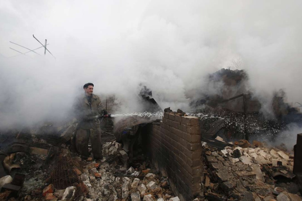 A firefighter douses a fire in Avdiivka, Ukraine, after heavy shelling by pro-Russian rebels on February 25. Photo: AFP