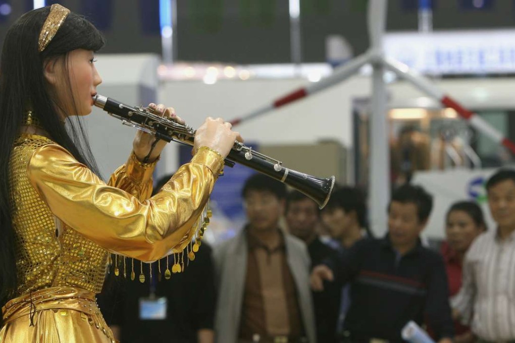 Visitors watch a robot plays a clarinet at the China International Industry Fair 2006 in Shanghai. Photo: Reuters
