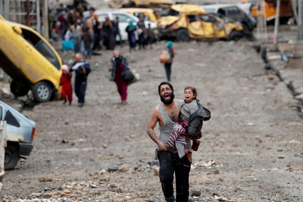 A man cries as he carries his daughter from an Islamic State-controlled part of Mosul towards Iraqi special forces soldiers during a battle in Mosul, Iraq, on Saturday. Photo: Reuters