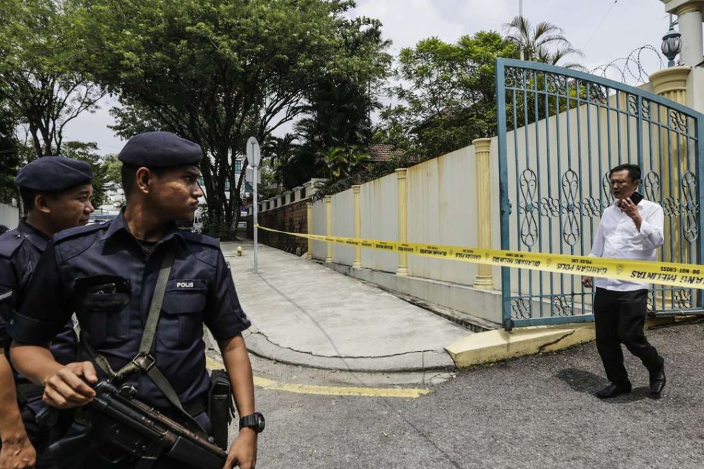 North Korean official walks towards armed police guarding outside the North Korean embassy in Kuala Lumpur. Photo: EPA