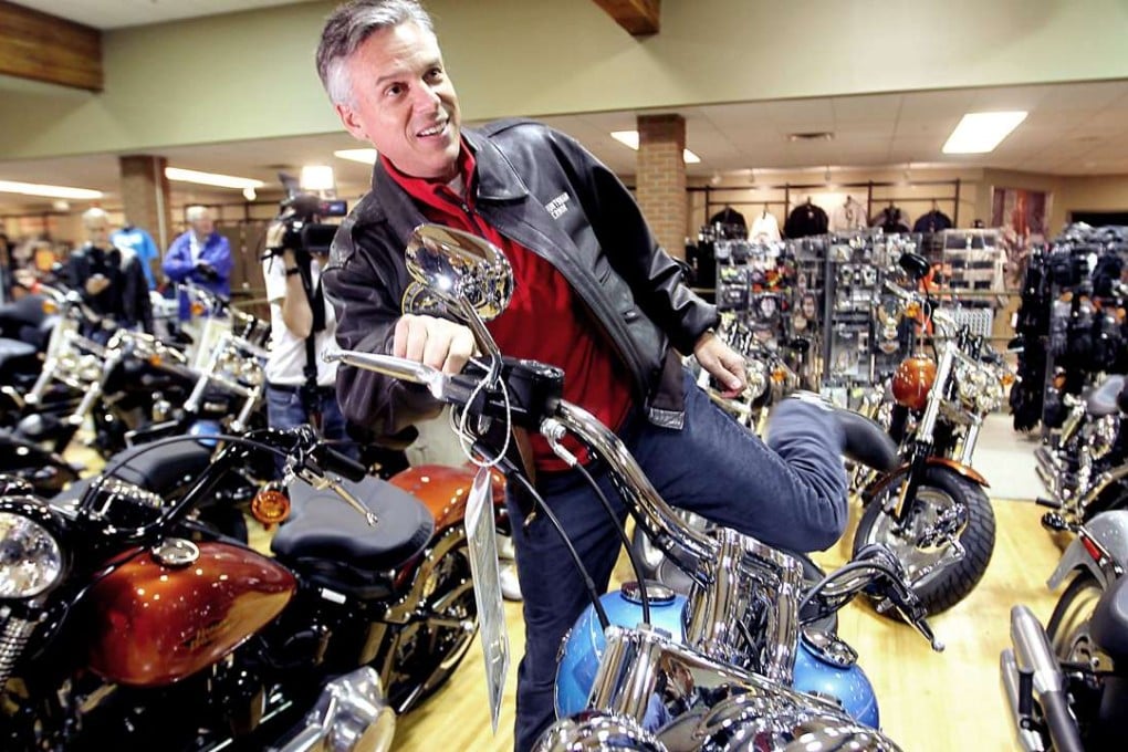 Jon Huntsman swings his leg over a Harley-Davidson at a showroom in Manchester, New Hampshire, in 2011. Photo: AP i
