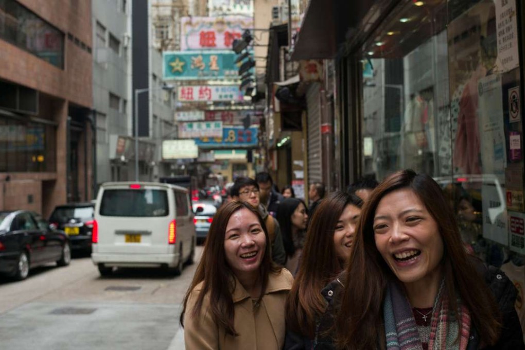 Pedestrians in Hong Kong share a laugh. Hong Kong has a role to play to help China to understand the world, Westernised and modern, and help the world understand and integrate with China. Photo: AFP