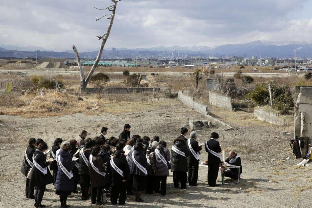 People offer prayers for victims killed by the magnitude earthquake and tsunami of 11 March 2011 at tsunami-devastated Arahama area in Sendai. Photo: EPA