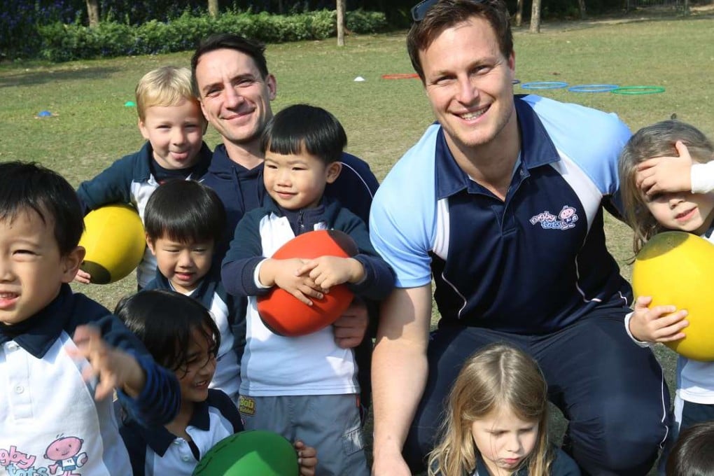 Rugbytots’ Ben Cullen (left) and Bryan Rennie with a class of keen kids. Photo: Dickson Lee