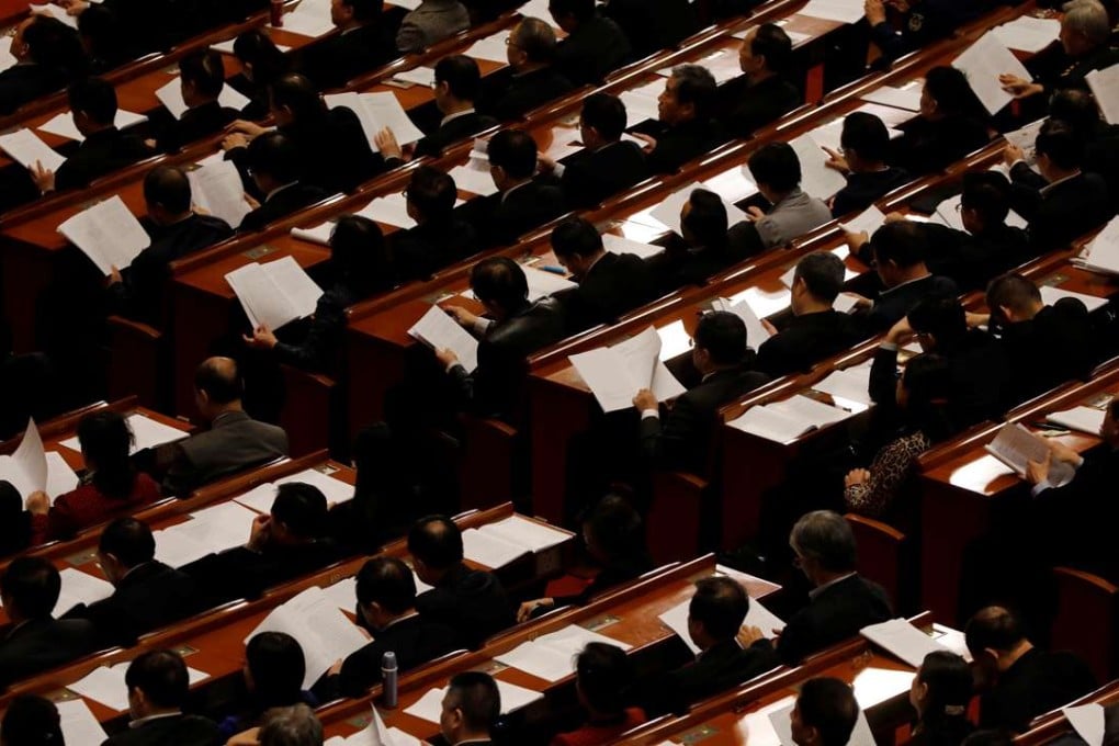 Delegates read papers at the Great Hall of the People in Beijing on Friday. Photo: Reuters
