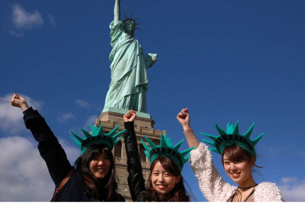 Japanese tourists pose in front of the Statue of Liberty last October. Photo: Reuters