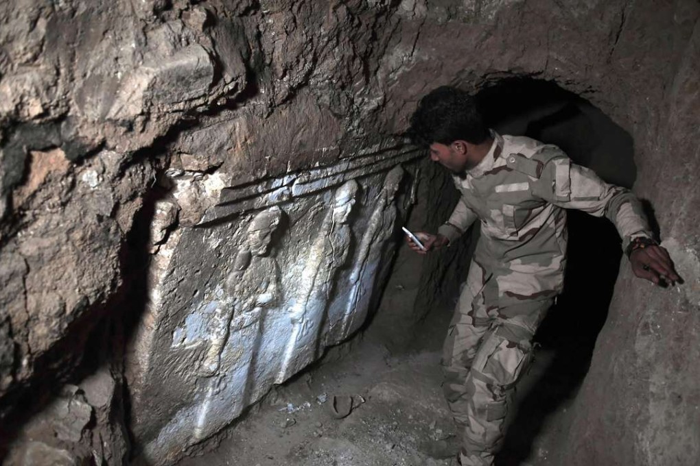 An Iraqi soldier stands next to archaeological findings inside an underground tunnel in east Mosul. Photo: AFP