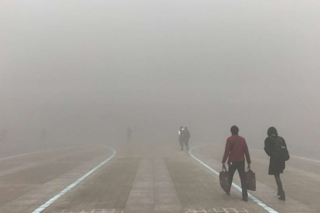 People walk through heavy smog in Zhengzhou, Henan province, in January. Photo: Reuters