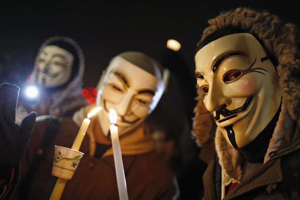 Protesters wearing Guy Fawkes masks take part in a candlelight vigil outside the Ferguson Police Department in Ferguson, Missouri, on November 21, 2014, after the police shooting of unarmed black teenager Michael Brown. Photo: Reuters