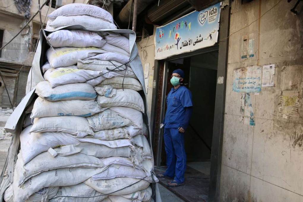 A medic stands behind sandbags at a damaged hospital. Photo: Reuters