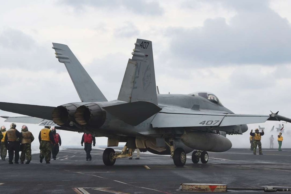 US Navy flight crew members stand near a single-seater F/A-18C Hornet fighter jet on the deck of the Nimitz-class aircraft carrier USS Carl Vinson. The nuclear-powered carrier arrived in South Korea on Wednesday to participate in an ongoing joint military exercise, the US navy said. Photo: AFP