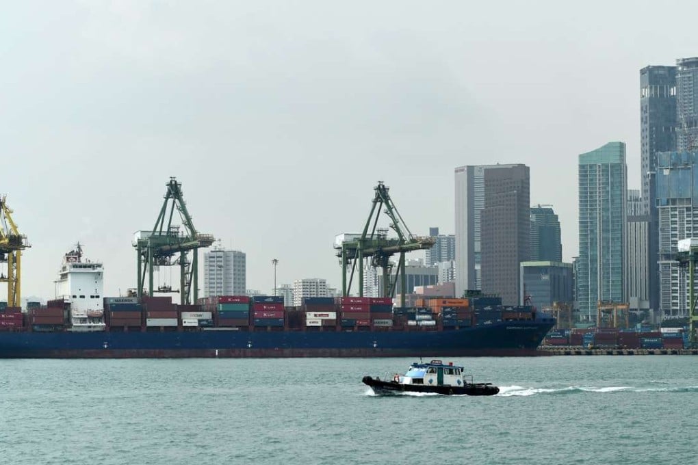 A boat leaving the pier passes Tanjong Pagar container terminal in Singapore on November 17. The city state is keen to compete for a leading position in regional maritime services, and Hong Kong must sharpen its edge. Photo: AFP