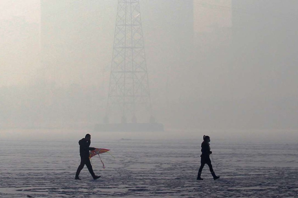 People walk on a frozen river amid thick smog in Shenyang in Liaoning province. Photo: Reuters