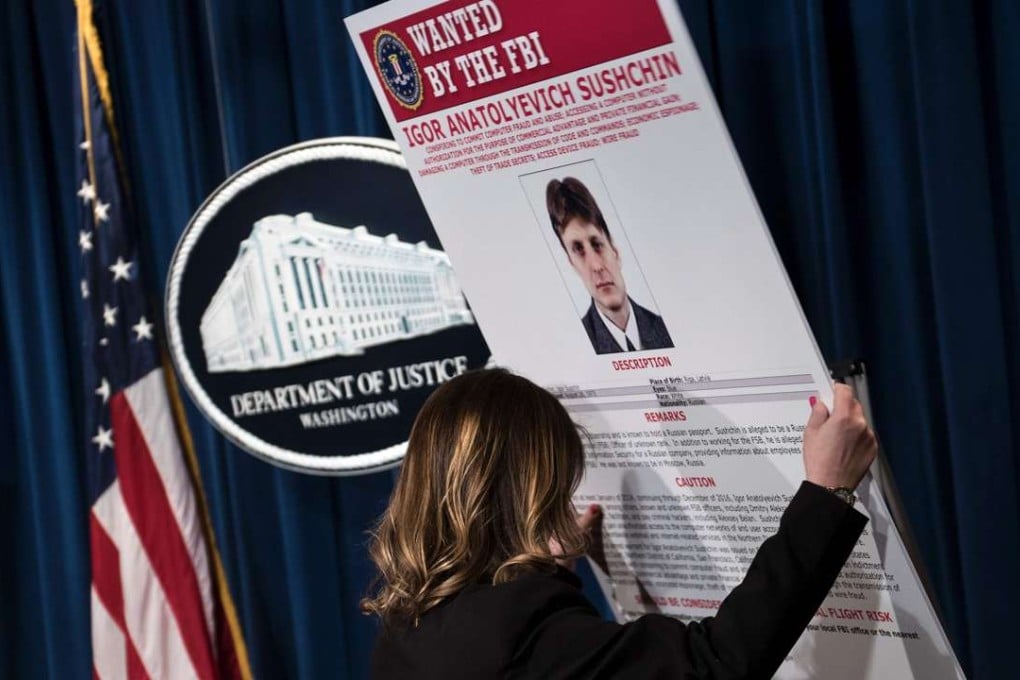 A staff member reveals a wanted poser of Igor Anatolyevich Sushchin, a Russian FSB agent charged for in the 2014 hacking of Yahoo, during a press conference at the US Department of Justice on Wednesday in Washington, DC. Two agents of Russia's FSB spy agency and two "criminal hackers" were indicted Wednesday over a massive cyberattaPhoto: AFP