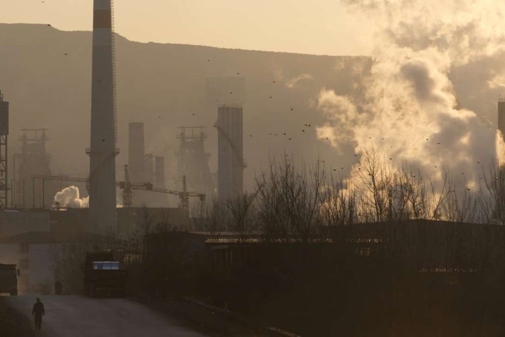 In this Dec. 29, 2016 photo, a man walks near the Shougang steel mills in Qianan in northern China's Hebei province. Faced with choking smog in the Chinese capital, Chinese media and policy circles often point to a list of culprits: the central government's inability to shut down polluting steel mills, the middle class's insatiable demand for cars, poorer segments of society's insistence on burning coal. (AP Photo/Ng Han Guan)