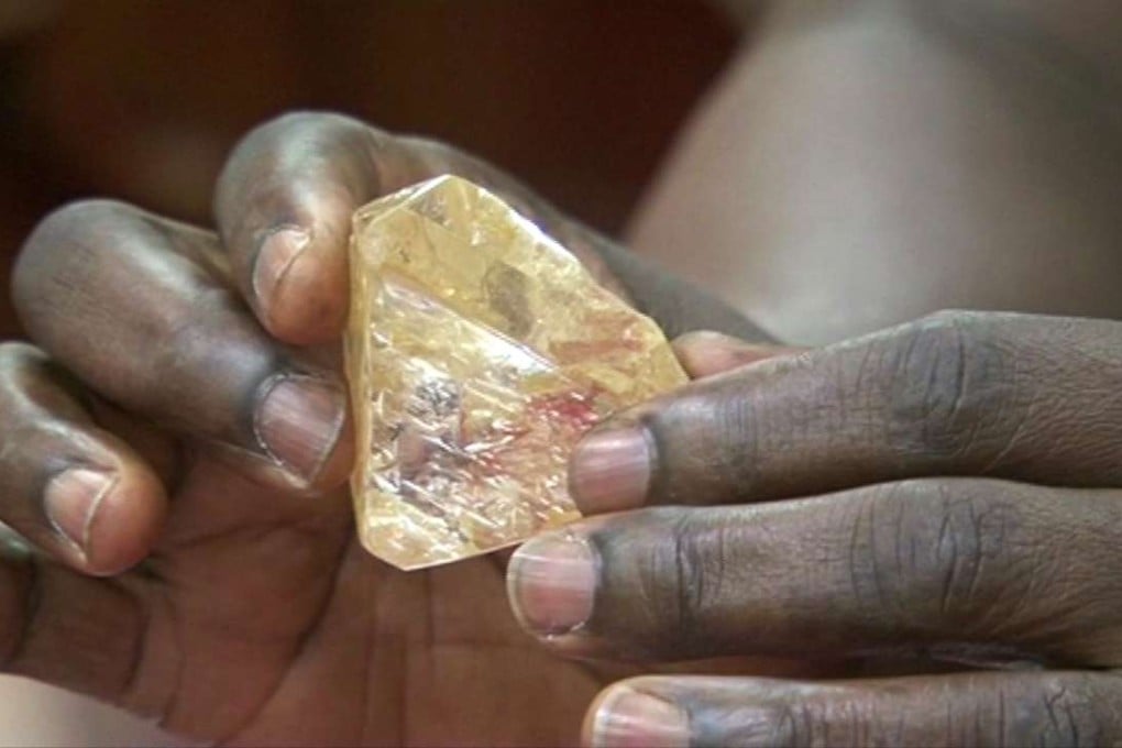 In this photo taken from video footage, Sierra Leone's President Ernest Bai Koroma handles a 706-carat diamond presented to him during a meeting with delegates of Kono district, where the gem was found, at the presidential office in Freetown, Sierra Leone, on Thursday. Photo: AP