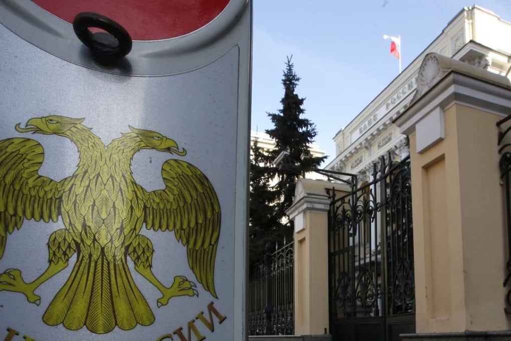 A road sign for parking, with the coat of arms of the Russian Central Bank seen on it, is placed near the headquarters of the bank in Moscow. Photo: Reuters
