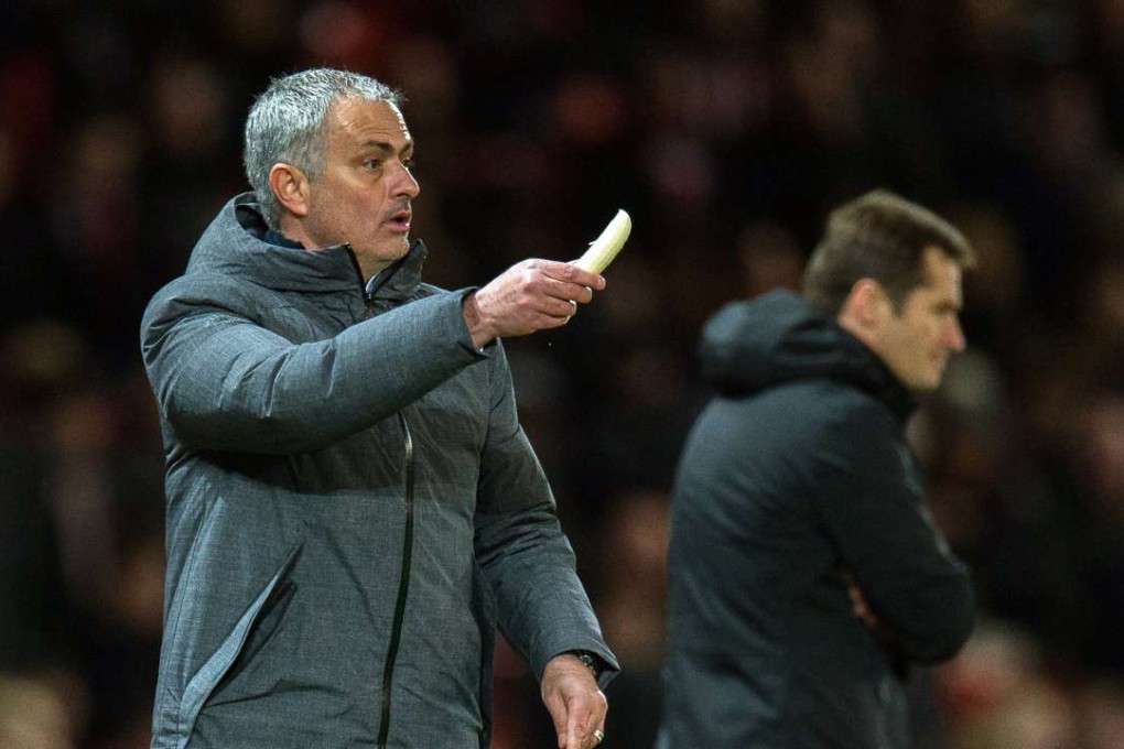 Manchester United manager Jose Mourinho peels a banana on the touchline before getting it to a tired Marcos Rojo to eat. Photo: EPA