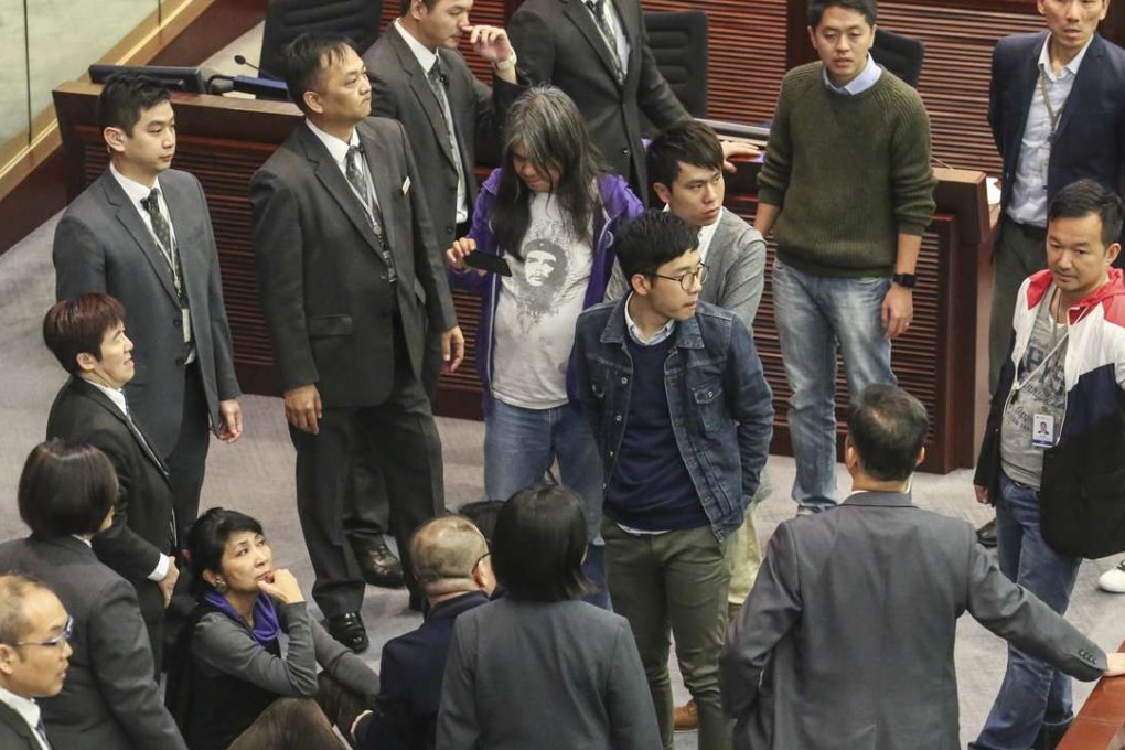 Pan-democratic legislators, including Claudia Mo and Nathan Law, ran to the chairman’s seat during the committee session. Photo: Edward Wong