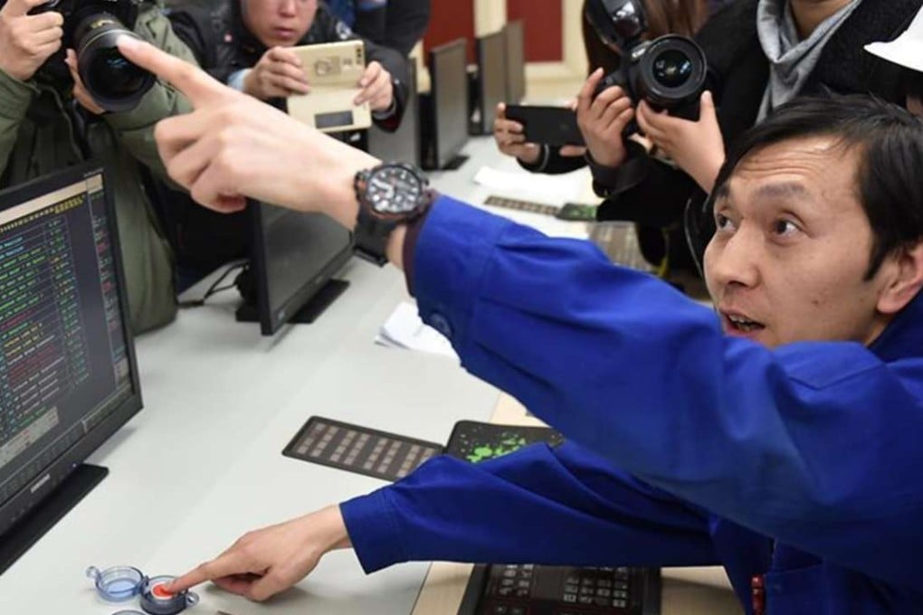 Cameras record the moment as an operator presses the stop button for the last turbine array operating at the plant. Photo: Xinhua
