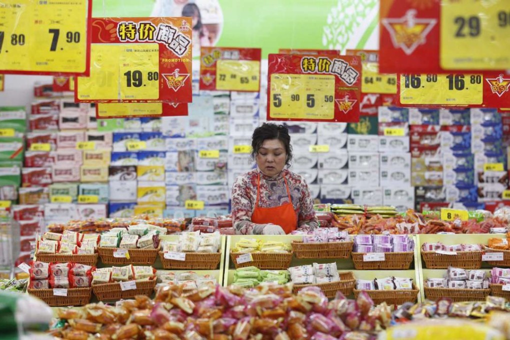 An employee arranges stock under price tags at a supermarket in Huaibei, Anhui province. Photo: Reuters