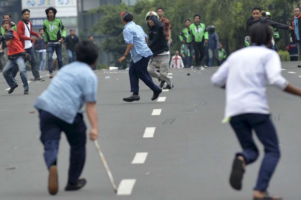 Taxi drivers clash with ride-sharing app drivers in Jakarta, Indonesia. Photo: Reuters