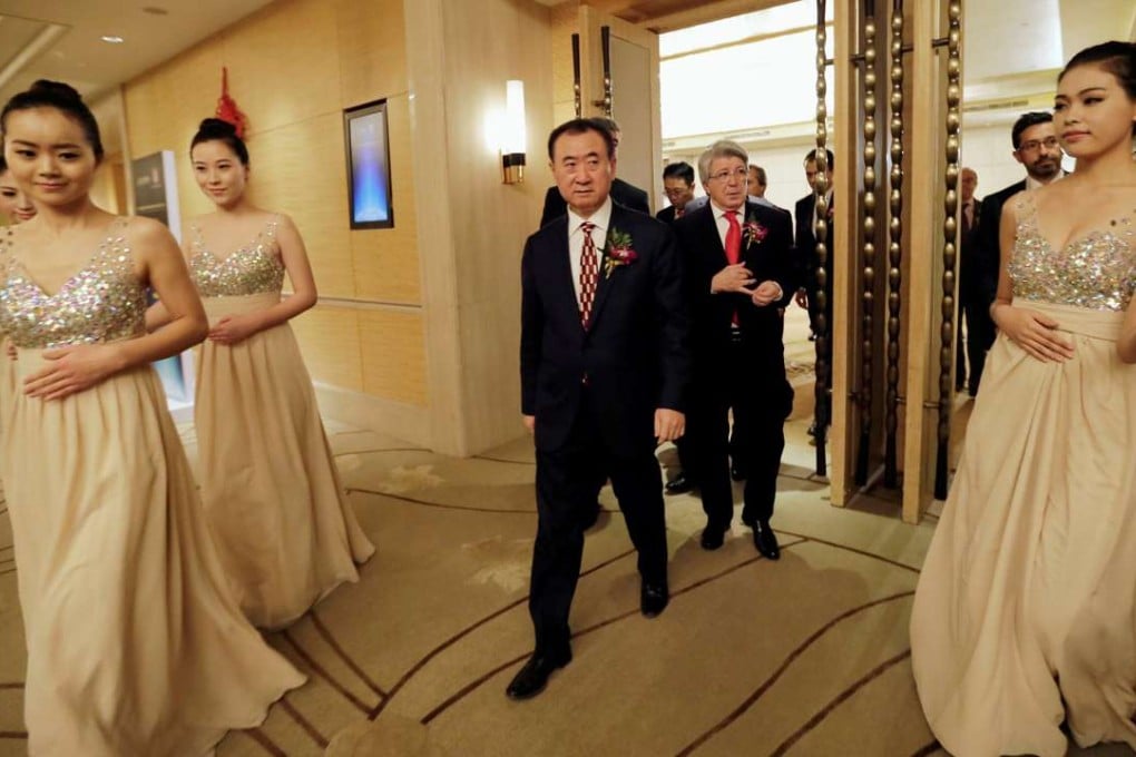 Wang Jianlin (centre), chairman of Dalian Wanda Group, and Atletico Madrid FC's president Enrique Cerezo arrive for a signing ceremony in Beijing. This week the Spanish footballl club reached agreement to move from the Vicente Calderon, their home for 50 years, to the new stadium to be renamed Wanda Metropolitano after their sponsors. Wanda has had ties with Atletico since January 2015, when it acquired 20 per cent of the club.