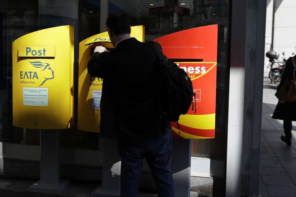 A man posting a letter at the central post office in Athens. Photo: AP