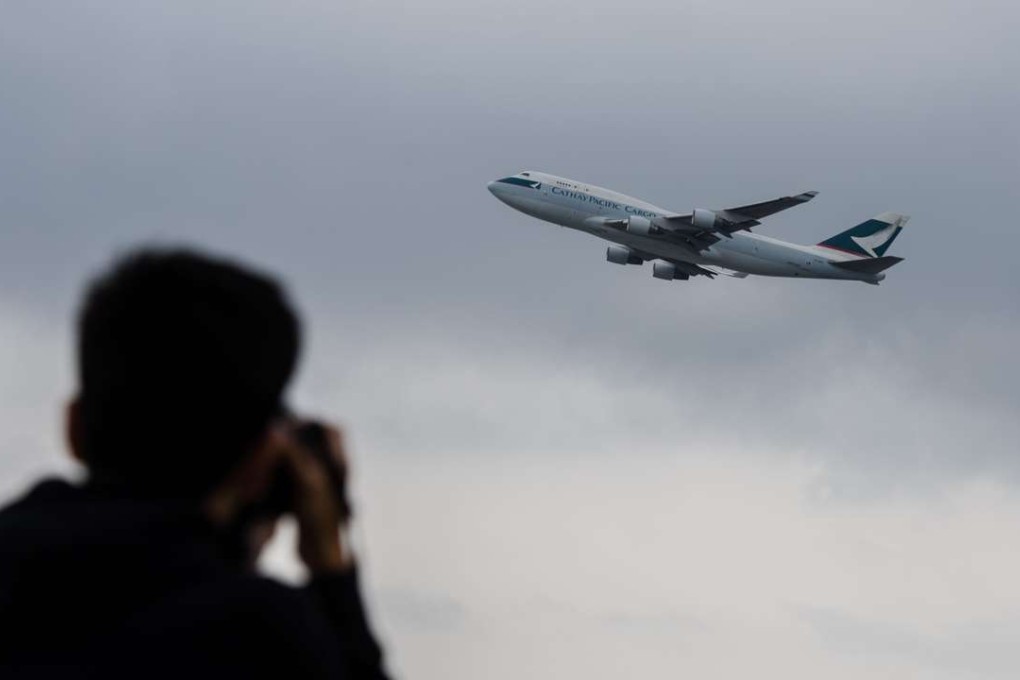 An aviation enthusiast photographs a Cathay Pacific cargo plane as it takes off from the international airport in Hong Kong this month. Symbolically, Cathay is to Hong Kong’s autonomy in the air what the territory’s political and economic institutions are to its special status on the ground. Photo: AFP