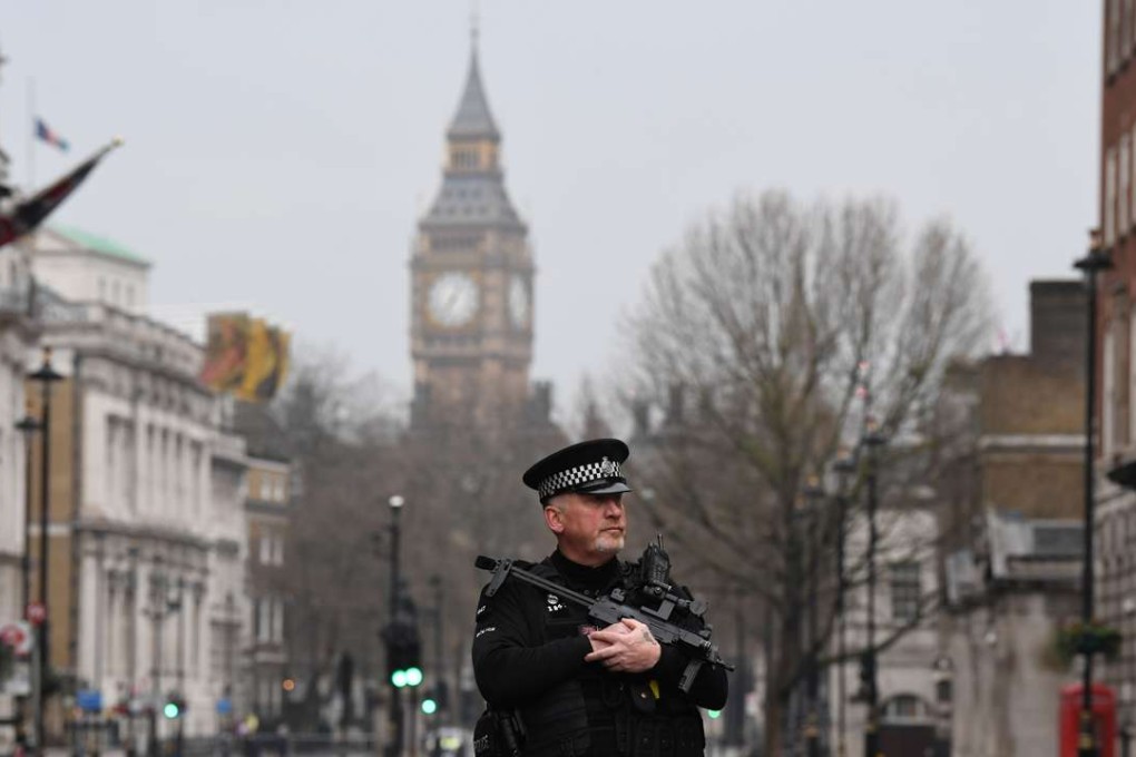 An armed police officer patrols a security cordon set up along Whitehall by the Houses of Parliament in London. Photo: AFP