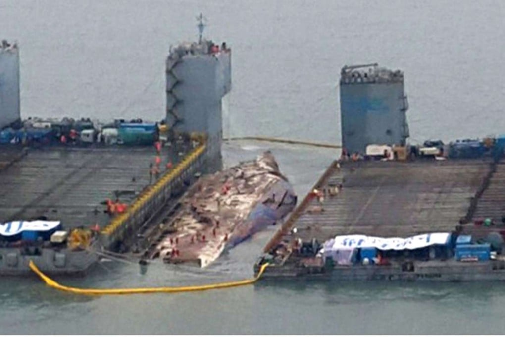 Workers prepare to lift the sunken Sewol ferry, centre, in waters off Jindo, South Korea. Photo: AP