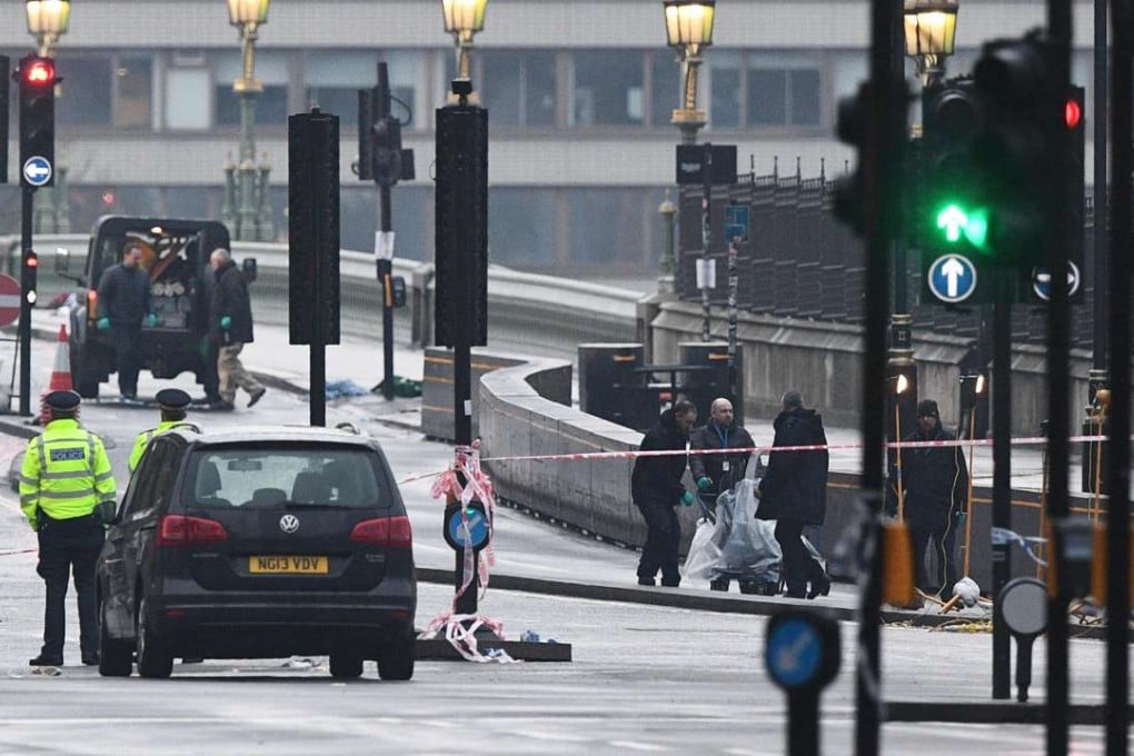 Security services staff collect debris left following the terror attack on Westminster Bridge. Photo: AFP