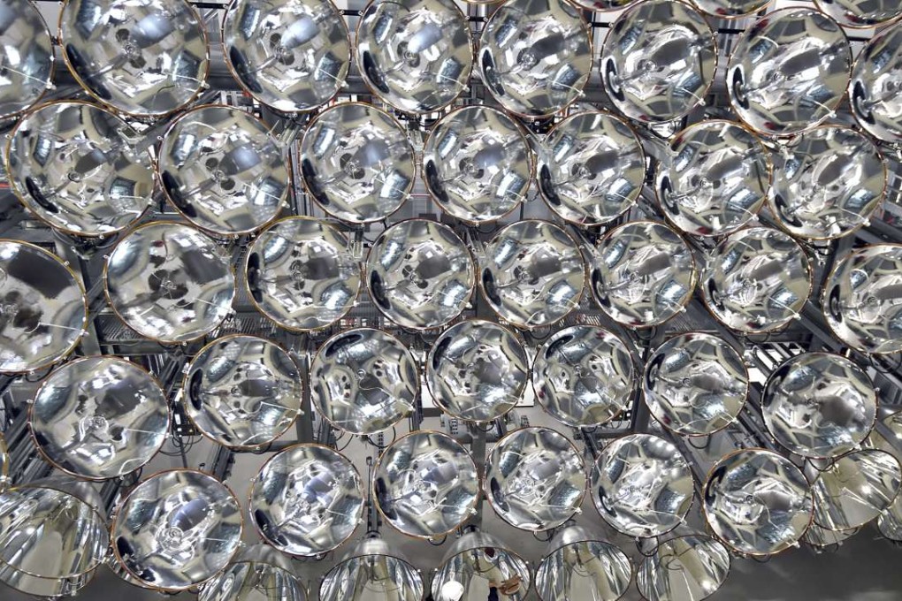 Engineer Volkmar Dohmen stands in front of xenon short-arc lamps in the DLR German national aeronautics and space research centre in Juelich, western Germany. The lights are part of an artificial sun that will be used for research purposes. Photo: AP