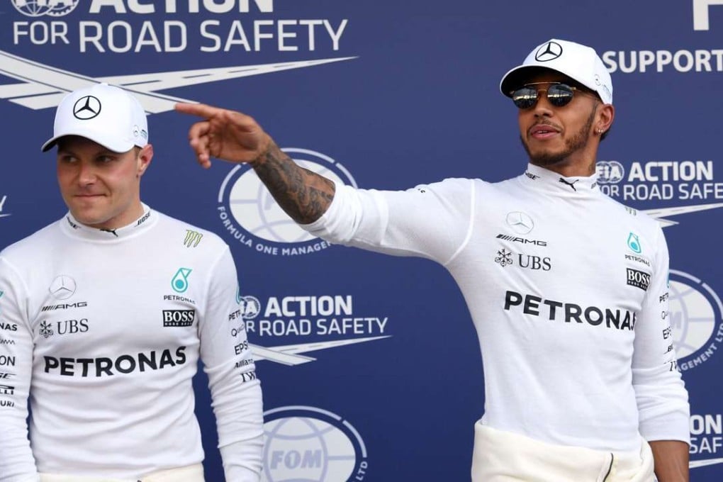 Mercedes' British driver Lewis Hamilton (R) and teammate Mercedes' Finnish driver Valtteri Bottas (L) celebrate. Photo AFP