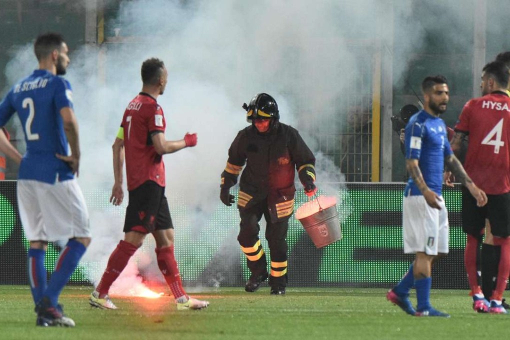 A fireman tries to clear the pitch. Photo: EPA