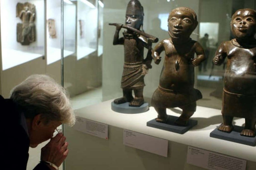 A visitor looks at brass statues during an exhibition focused on refined art from Benin at the Quai Branly museum in Paris. File photo: AFP