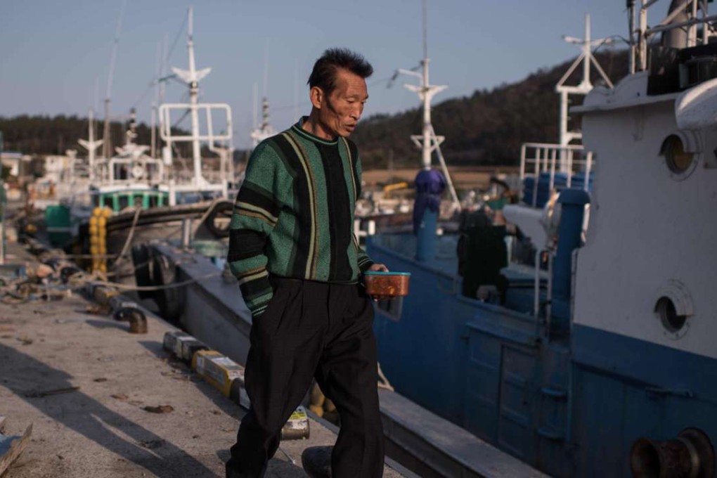 A fisherman at a small fishing port adjacent to Paengmok harbour. Photo: AFP