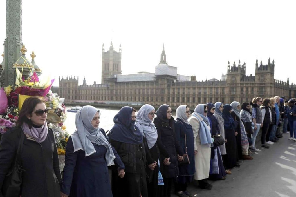 Participants in the Women's March, gather on Westminster Bridge to hold hands in silence, to remember victims of the attack in Westminster earlier in the week, in London on Sunday. Photo: Reuters