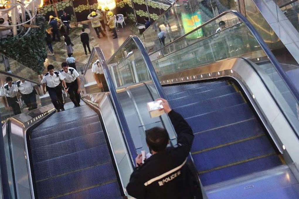 Police officers investigate an escalator after it malfunctioned at Langham Place shopping mall in Mong Kok. At least 17 people were injured. Photo: Felix Wong