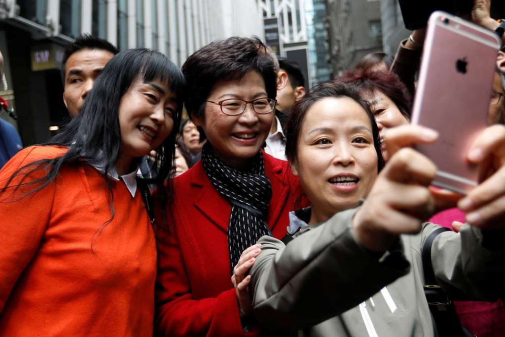 Carrie Lam, chief executive-elect, takes selfies with supporters a day after she won the chief executive election in Hong Kong. Photo: Reuters