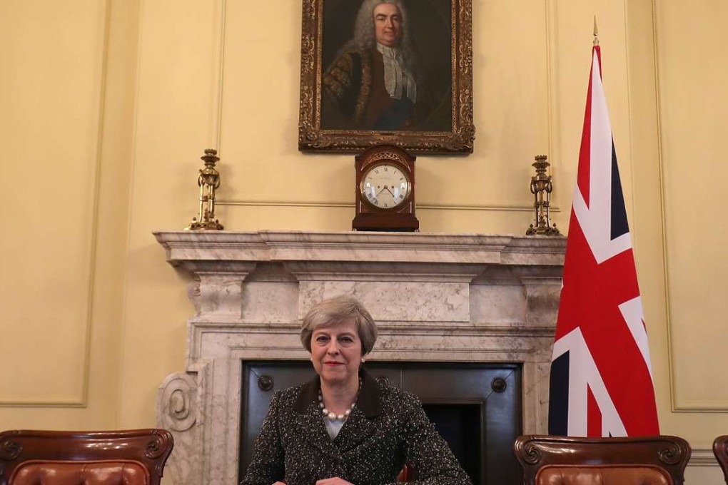 British Prime Minister Theresa May in the cabinet, sitting below a painting of Britain's first Prime Minister Robert Walpole, signs the official letter to European Council President Donald Tusk invoking Article 50 and the United Kingdom's intention to leave the EU on March 28, 2017 in London, England. Photo: Reuters