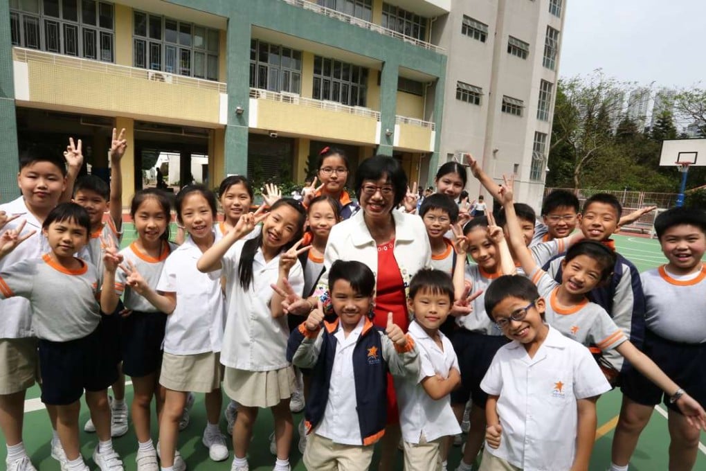 Principal Wong Kwai-ling for HKUGA Primary School in Chai Wan, posing with students. Photo: Jonathan Wong