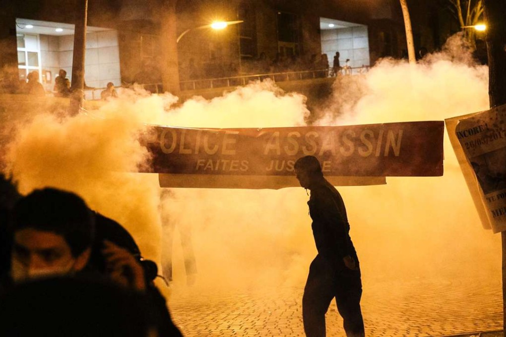 Anti-riot police throw during a protest in front of the police headquarters in the 19th arrondissement of Paris. Photo: AFP